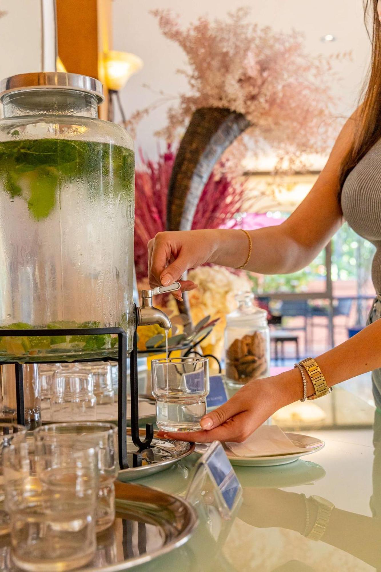 מלון Radisson Blu Martinez ביירות מראה חיצוני תמונה A woman filling a glass with a beverage